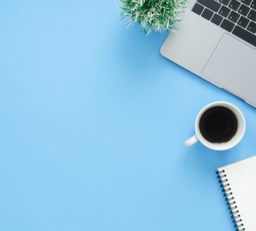 laptop and coffee mug from above on blue background