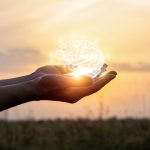 Hand holding brain made of light