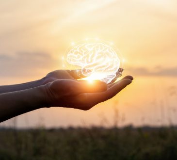 Hand holding brain made of light
