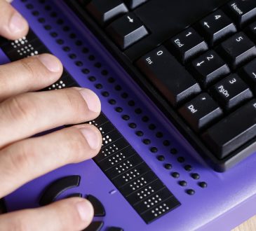 Blind person using computer with braille computer display