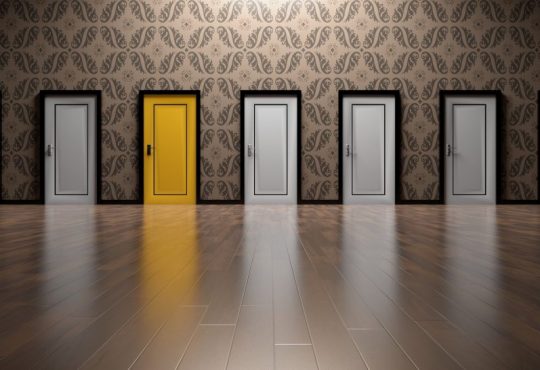 series of white doors with one yellow door in middle
