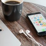 Phone on table beside laptop and coffee mug