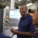 Engineer Training Apprentices On CNC Machine