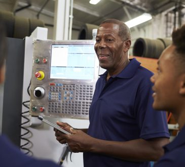 Engineer Training Apprentices On CNC Machine