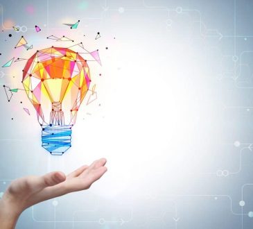 colourful lightbulb hovering over open palm of hand