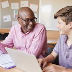 male teacher talking with male high school student