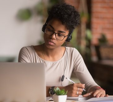 woman wearing headphones watching webinar