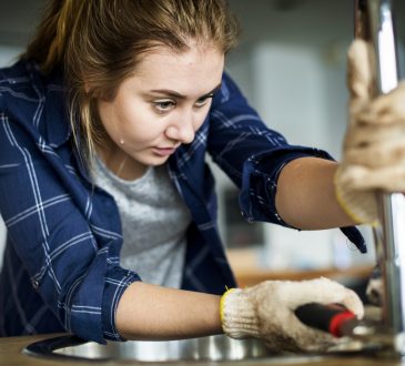Woman fixing kitchen sink