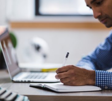 man writing in notebook