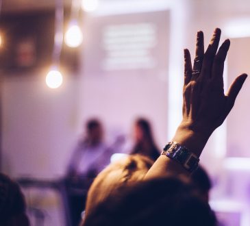 person in audience raising hand