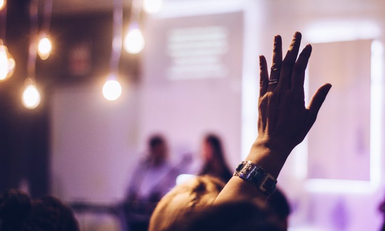 person in audience raising hand