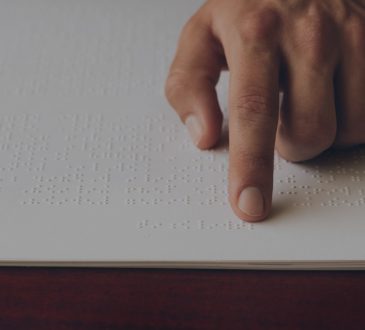 close up of hand of person reading braille