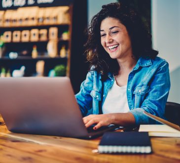 Woman watching video on laptop in cafe