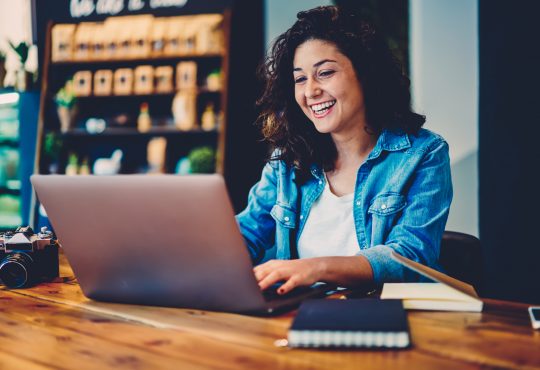 Woman watching video on laptop in cafe