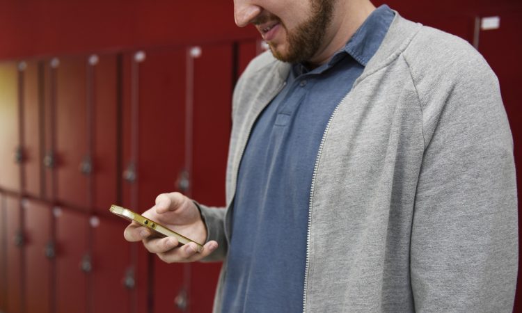 man looking down at cellphone in hand