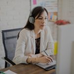 woman wearing headphones while working at desk
