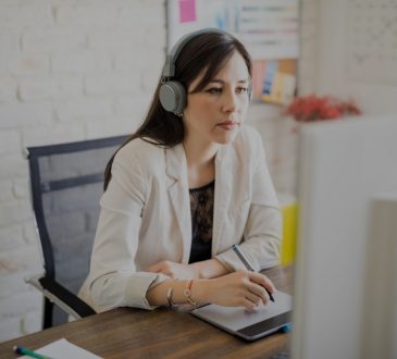 woman wearing headphones while working at desk