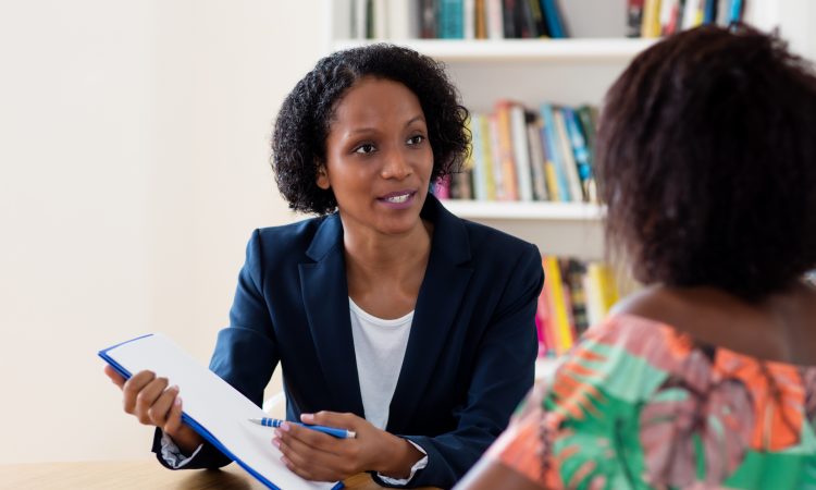 two woman talking at table
