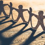 Human chain made from paper on wood table