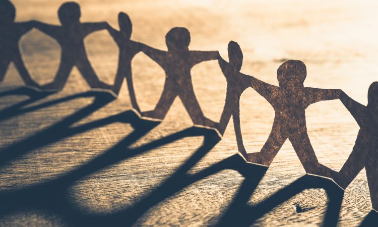 Human chain made from paper on wood table