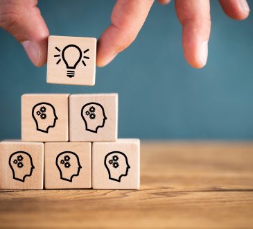many people together having an idea symbolized by icons on cubes on wooden background