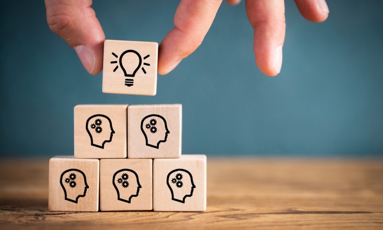 many people together having an idea symbolized by icons on cubes on wooden background