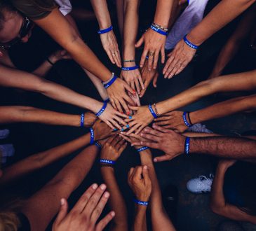 group of people huddling with hands in centre