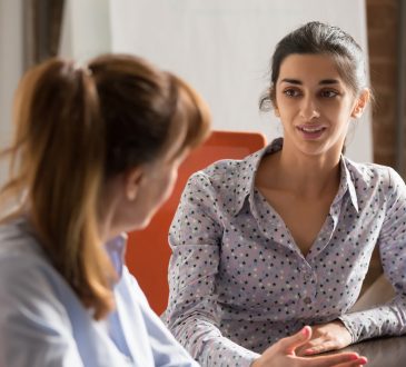 two women speaking in office