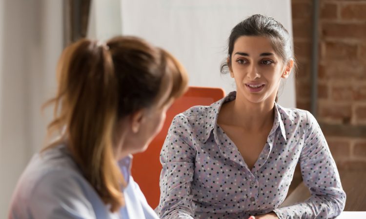 two women speaking in office