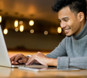 happy man typing on laptop