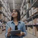 women in warehouse holding clipboard