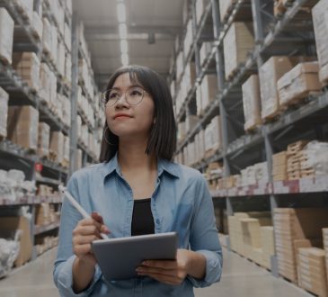 women in warehouse holding clipboard