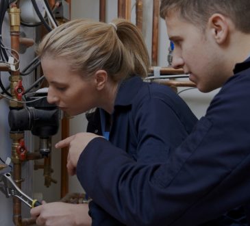 Two plumbing students looking at pipes