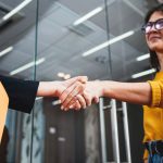 two people shaking hands in office