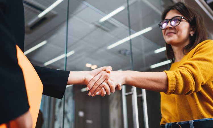 two people shaking hands in office