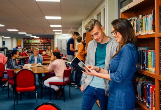 teacher with student in library