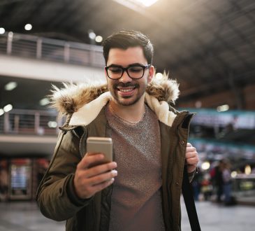 man using mobile in the train station