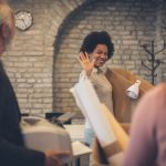 woman waving to colleagues leaving office