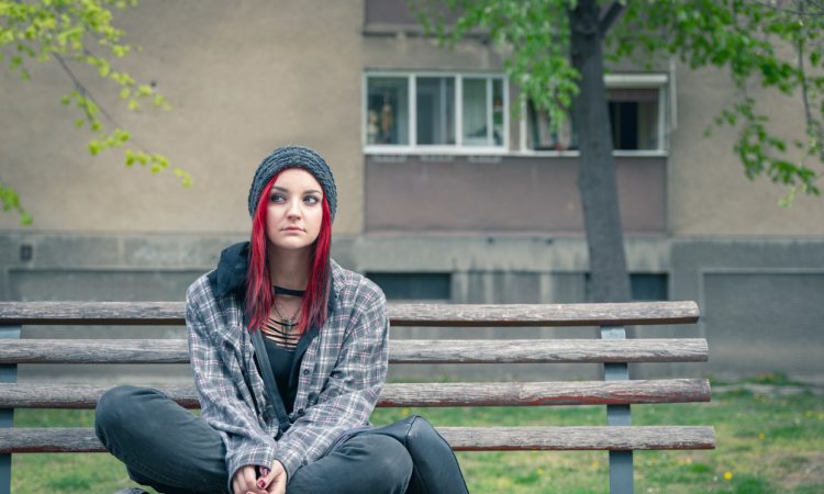 young women sitting cross-legged on bench