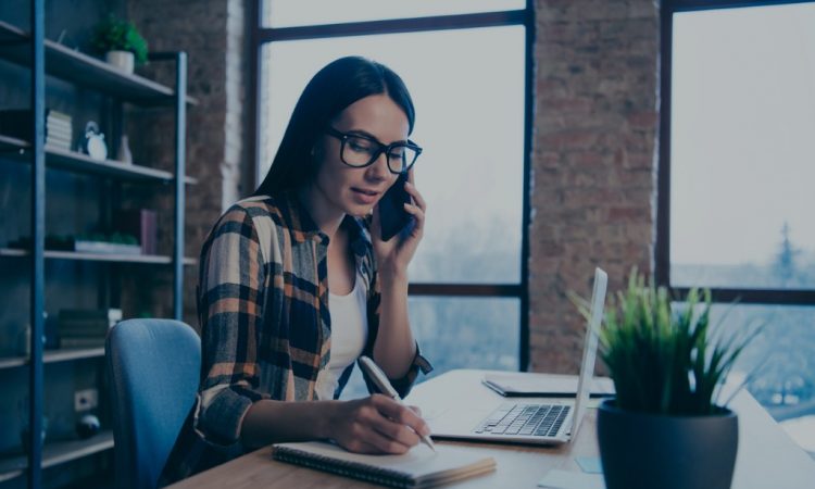 woman on phone taking notes