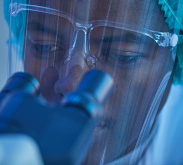 close up of man looking through microscope