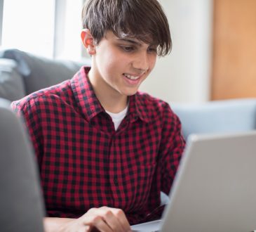 Teenage Boy Working On Laptop At Home