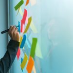 Businesswoman writing on colorful sticky note paper