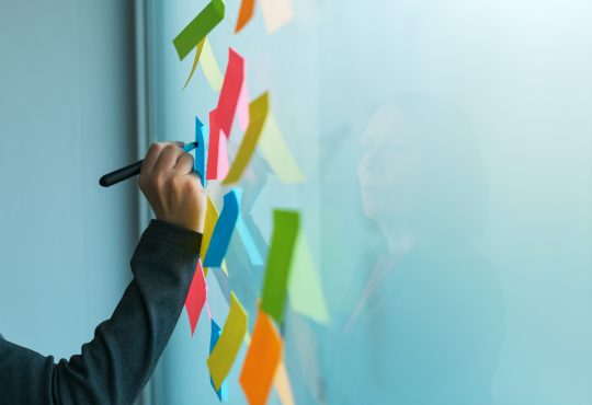 Businesswoman writing on colorful sticky note paper