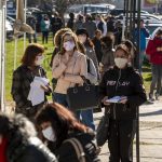 People wearing face masks in an attempt to prevent the spread of coronavirus disease COVID-19 wait in line in front of an office of the labor bureau.