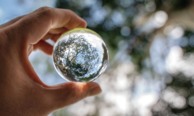 blue sky, white clouds and trees in a glass ball