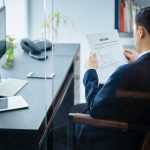 businessman reviews resume in office