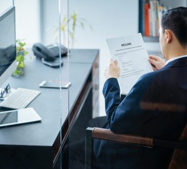 businessman reviews resume in office
