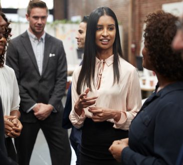 Business Team Standing Having Informal Meeting In Modern Office