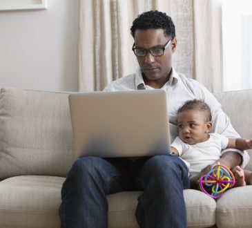 Father working from home and taking care of baby